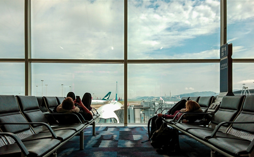 An airport waiting area overlooking planes outside.